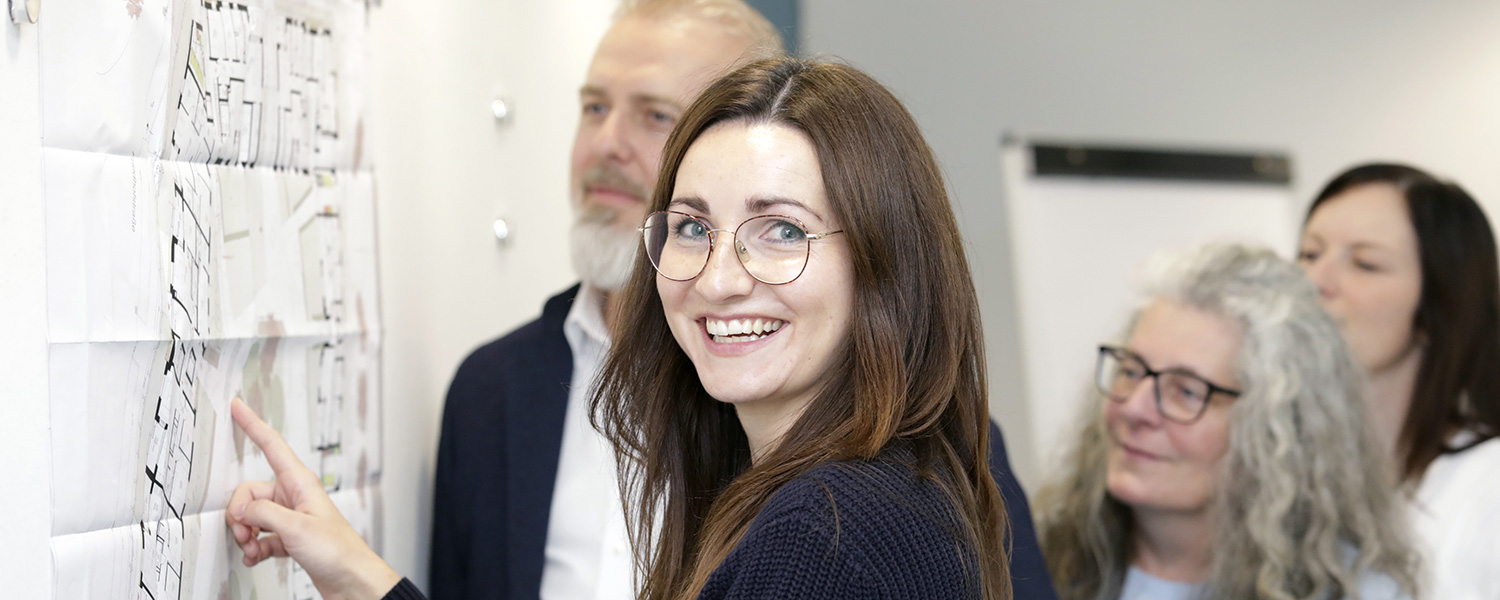 Vier Mitarbeitende der SWV arbeiten gemeinsam an einem Architekturplanrplan